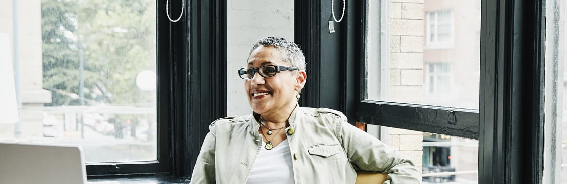 A smiling business owner seated in her workspace